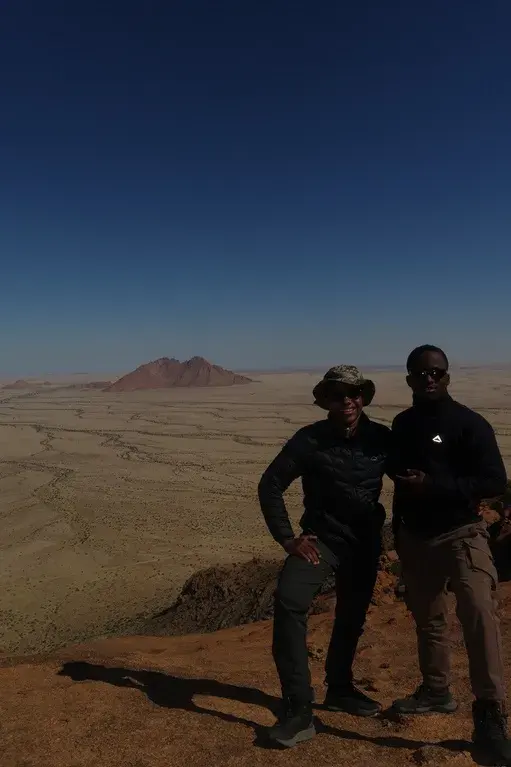 Brooklyn and John-Isaac on a rocky hilltop above the plains