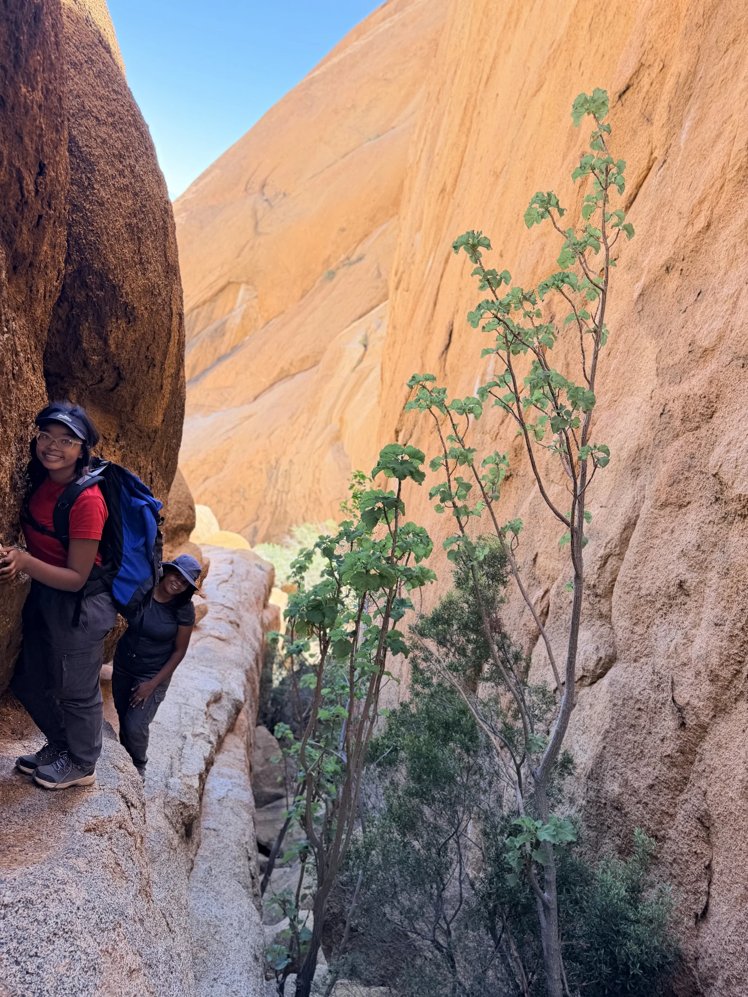 Hikers smiling in a granite gully on the route to the false summit of Gross Spitzkoppe