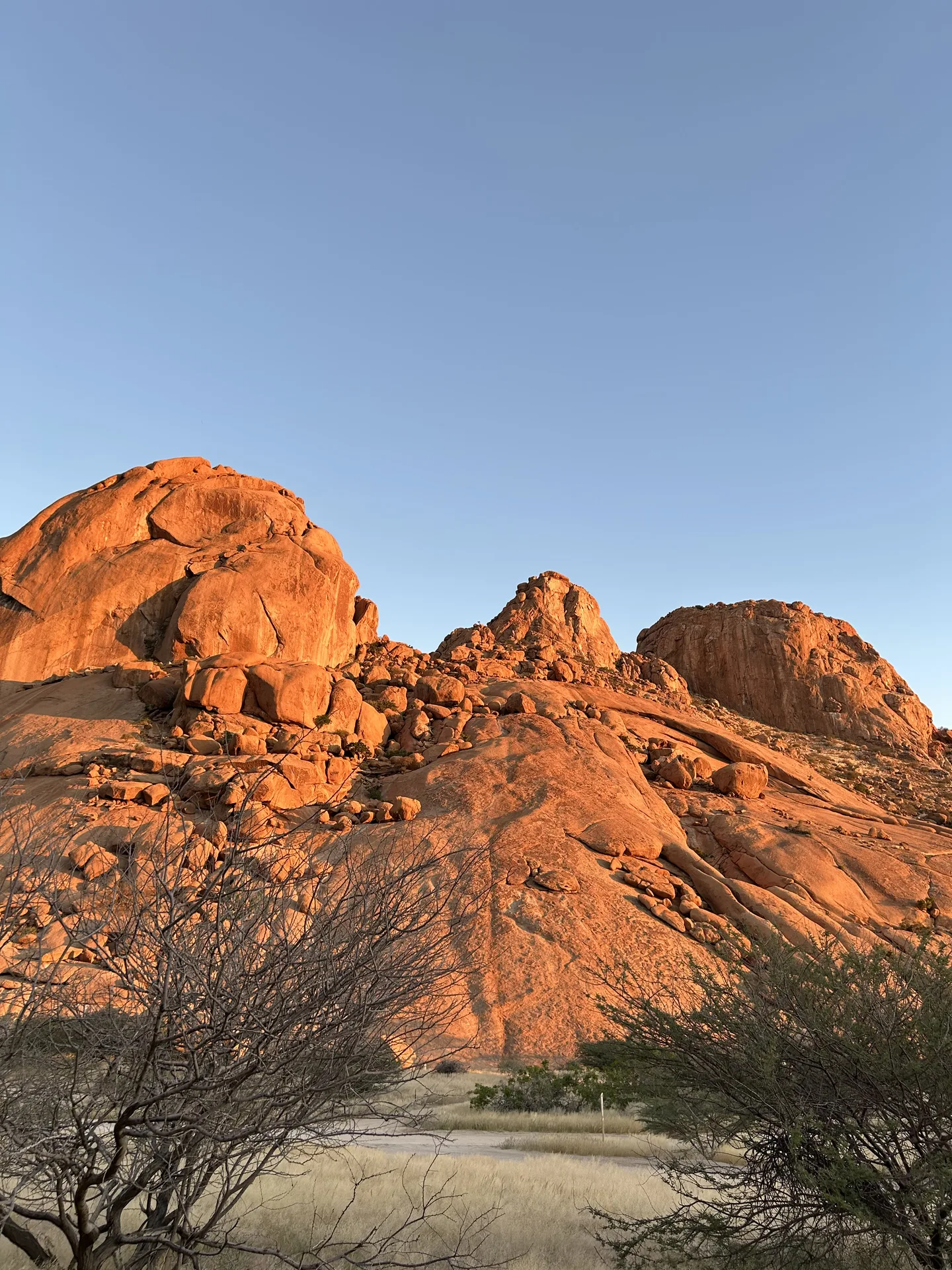 Massive granite domes of Spitzkoppe glowing warm orange at sunset